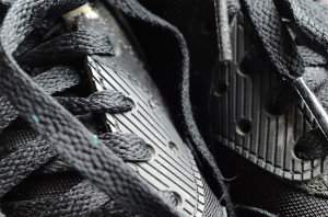 Pair of black trainers seen close up by the laces