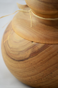 A turned wooden pot with a round lid on top