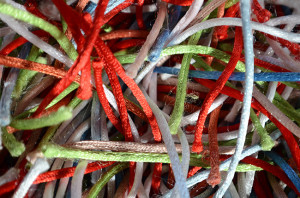 a jumble of bright colour synthetic threads on a rug