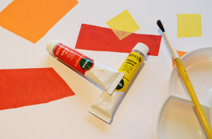 White background with red and yellow shapes. Yellow paintbrush and palette lower left. REd and yellow paint tubes in the middle