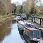 Looking down a river with canal boats moored along the right hand side