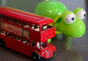 Toy double decker bus beside a bright green wind up tortoise